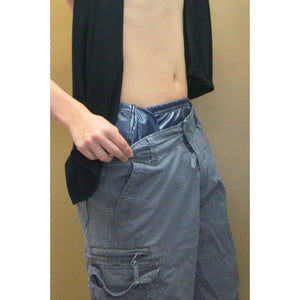 Young man showing how discreet wearing SOSecure Containment Swim Brief in Adult & Youth Style can be under swim trunks for incontinence protection